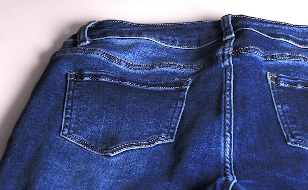 Nieuwe spijkerbroek op witte achtergrond, denim jeans textuur. Jeans achtergrond