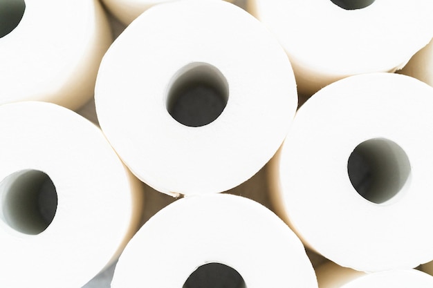 Foto nieuwe witte wc-papier rollen op een grijze achtergrond.