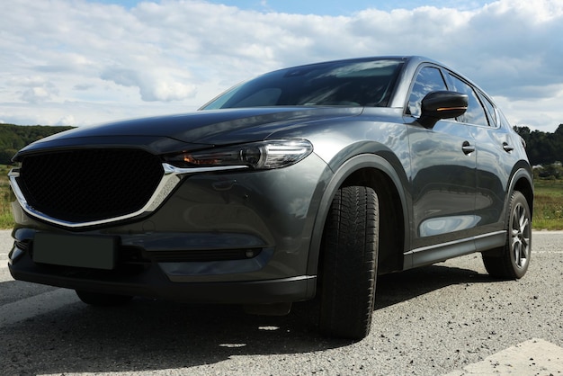Nieuwe zwarte moderne auto geparkeerd buiten lage hoekmening