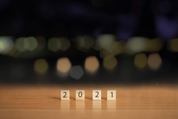 Nieuwjaar 2021 met houten kubus op tafel met bokeh achtergrond wazig.