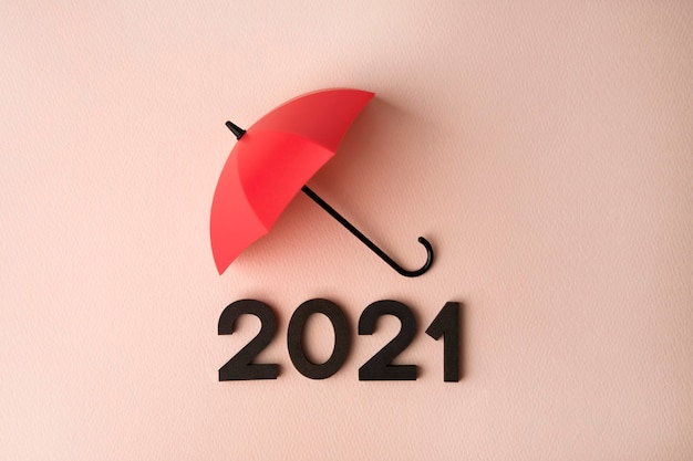 Nieuwjaar 2021 met rode paraplu op roze ondergrond