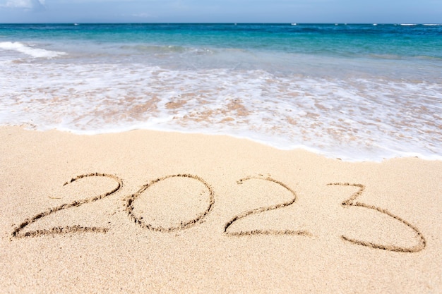 Nieuwjaar 2023 belettering op het strand met wave