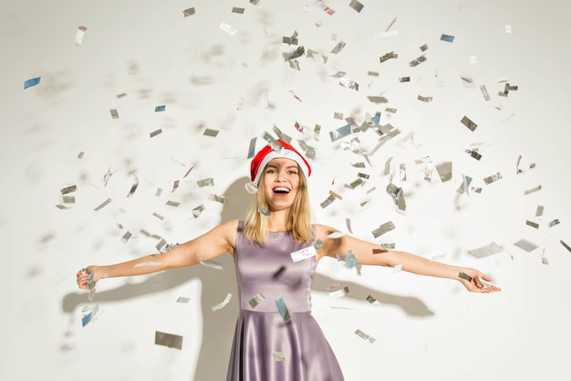 Nieuwjaar en vakantie concept - Happy opgewonden jonge vrouw in Kerstman hoed dansen en lachen op witte achtergrond.