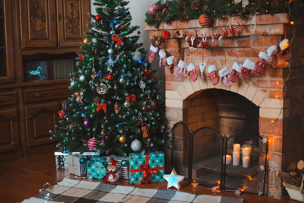 Nieuwjaar feestelijk interieur. Kerstboom versierd bij de open haard.