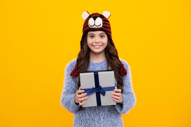 Nieuwjaar of kerstvakantie cadeau Gelukkig tiener positieve en lachende emoties van tiener meisje kind met geschenk huidige doos op geïsoleerde studio achtergrond Gifting voor kinderen verjaardag