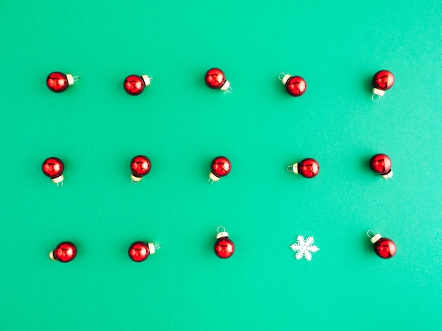 Nieuwjaar patroon, lay-out, plat leggen. Veel rood kerstboomspeelgoed ligt op een groene achtergrond.