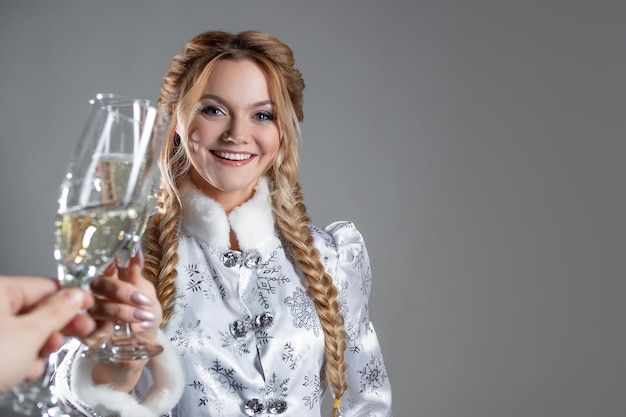 Nieuwjaar toast een jonge mooie blondine in een sneeuwkoningin kostuum rammelt een glas champagne foto o...