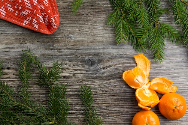 Nieuwjaars- en kerstversieringen op een houten oppervlak met mandarijnen en een groene kerstboom