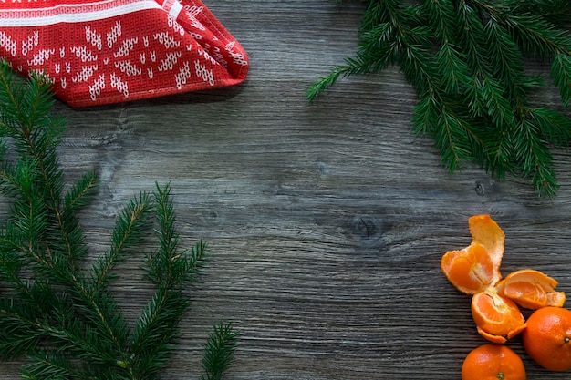 Nieuwjaars- en kerstversieringen op een houten oppervlak met mandarijnen en een groene kerstboom