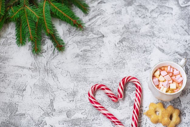 Nieuwjaars- of kerstsamenstelling van vuren groene takken, nieuwjaarslollies, beker met marshmallows en koekjes