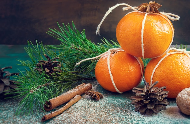 Nieuwjaarsamenstelling met mandarijnen, vuren takken, dennenappels en noten.