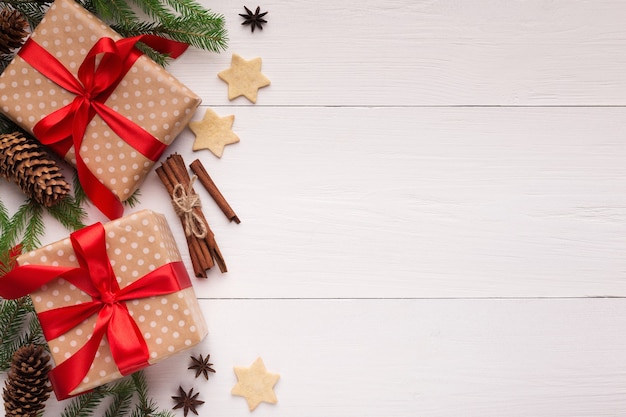 Nieuwjaarscadeautjes met koekjes en kaneel op een witte houten ondergrond, bovenaanzicht, kopieerruimte