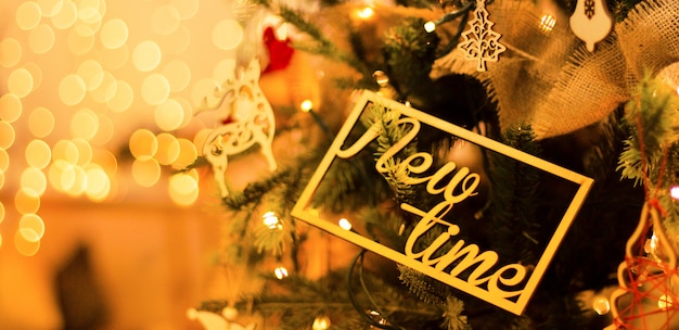 Foto nieuwjaarsdecoratie op de kerstboom met prachtige lichtgevende gele vervaagt