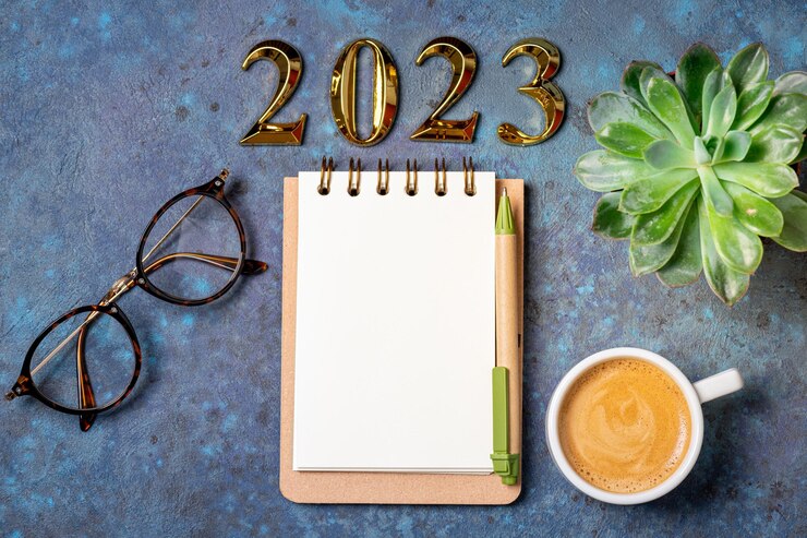 Foto nieuwjaarsdoelen 2023 op het bureau 2023 resolutielijst met notitieboek koffiebeker en kerstboom op de blauwe tafel resoluties plan doelen actie checklist concept nieuwjaar 2023 sjabloon kopieerruimte