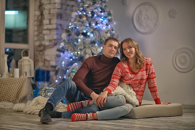 Nieuwjaarsfoto mensen / jonge man en meisje in het kerstinterieur, gezellig ingericht huis