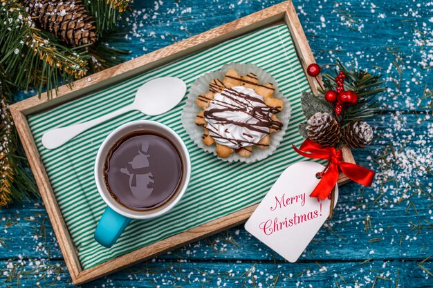 Nieuwjaarsfoto van thee met sneeuwpop, cake op tafel met vuren takken, ansichtkaarten met kerstwens