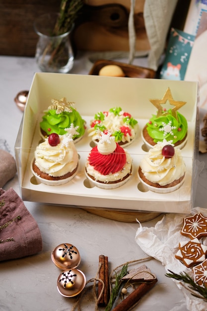 Nieuwjaarsgeschenksets met snoep. een doos cupcakes als kerstcadeau. taarten met cream cheese cream en pinda-karamel vulling.