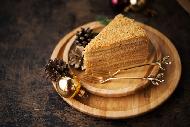 Nieuwjaarsidee voor een feestelijk dessert. Zelfgemaakte honing cake op donkere muur.