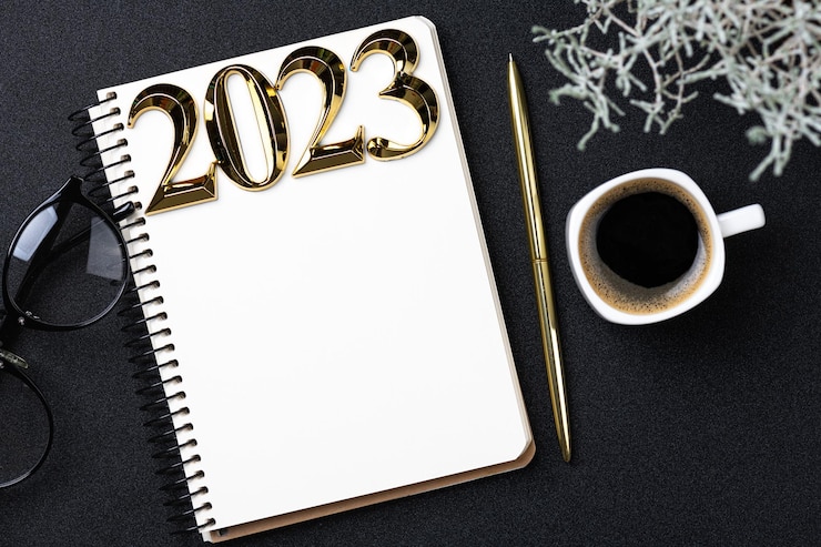 Foto nieuwjaarsresoluties 2023 op het bureau 2023 resolutieslijst met notebook koffiebeker op zwarte achtergrond doelen resoluties plan actie checklist concept nieuwjaar 2023 sjabloon kopieerruimte