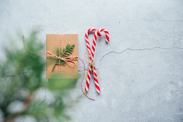 Nieuwjaarssamenstelling met kerstcadeaudoos dennenappels en thuja-takken