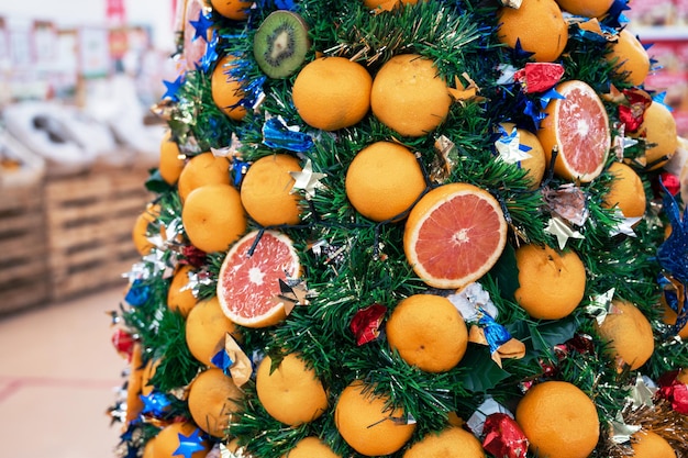 Nieuwjaarsspar versierd met fruit in supermarkt