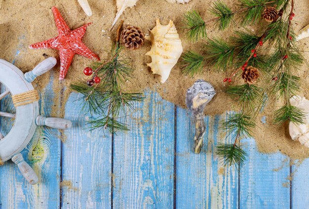 Foto nieuwjaarsvakantie zeelieden kapiteins wiel met schelpen zeesterren zand op blauwe houten planken