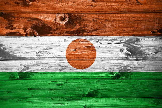 Niger flag on wooden planks background