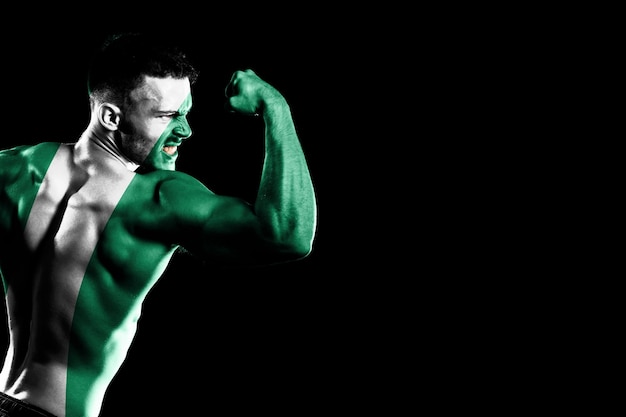 Nigeria flag on handsome young muscular man black background