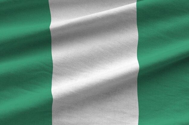 Nigeria flag with big folds waving close up under the studio light indoors The official symbols and colors in banner