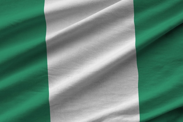 Nigeria flag with big folds waving close up under the studio light indoors the official symbols and 