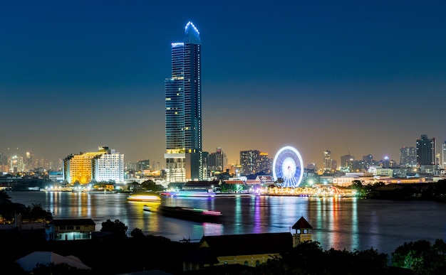 Photo night architecture business office building and ferris wheel in bangkok