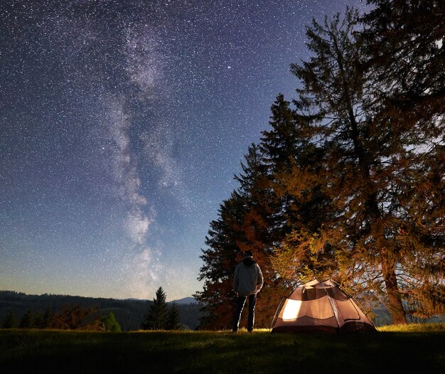 Night camping in mountains under starry sky and Milky way