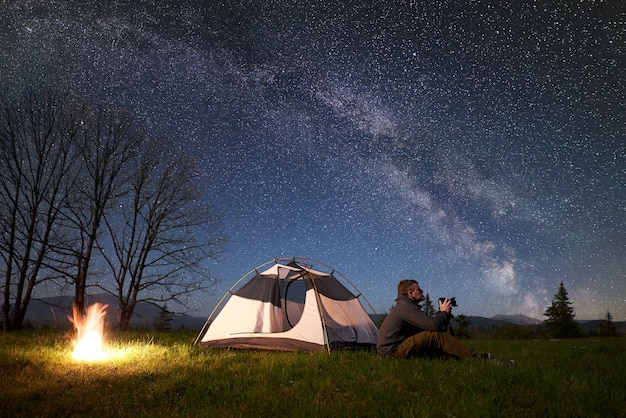 Night camping in mountains under starry sky and Milky way