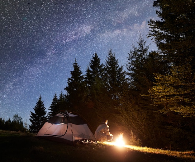 Night camping in mountains under starry sky and Milky way