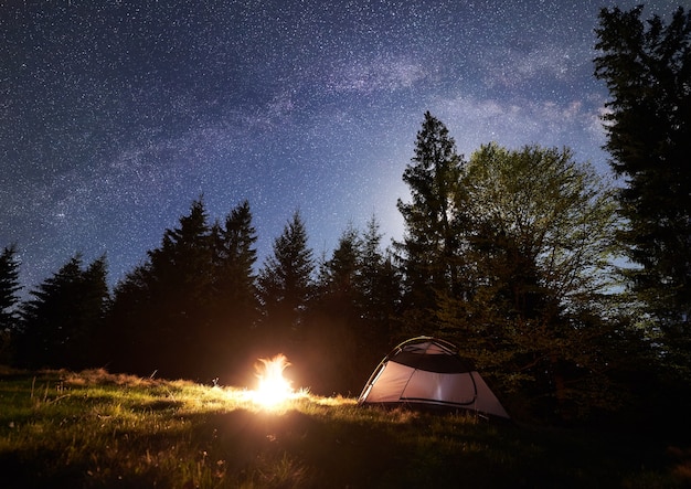Night camping in mountains under starry sky and Milky way