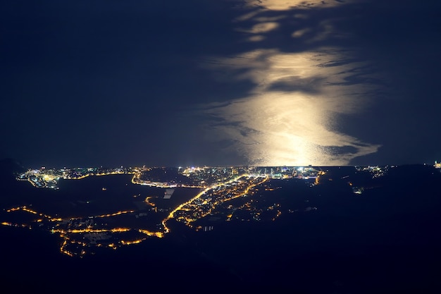 Night city of Tekirova in Turkey with moonlight on the sea
