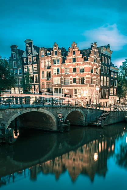 Vista della città di notte del canale e del ponte di amsterdam