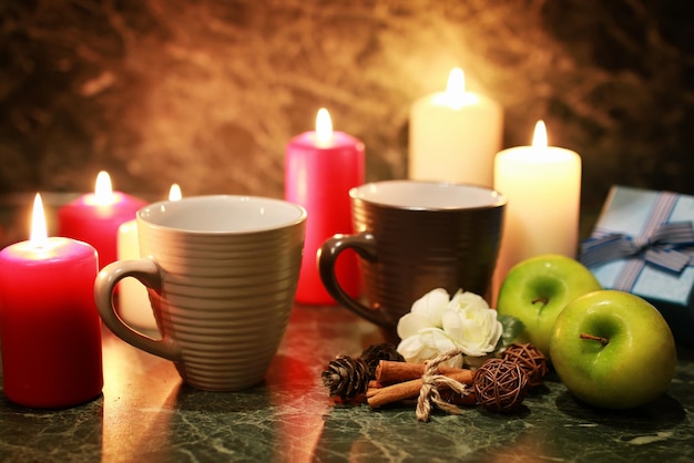 Night cup of tea with candle and apple