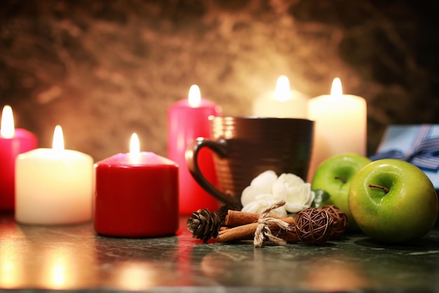 Night cup of tea with candle and apple