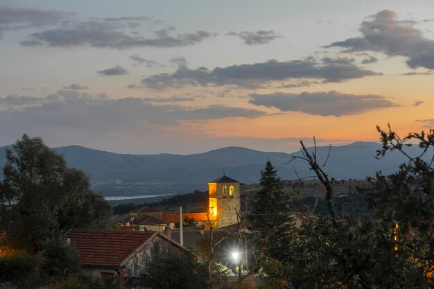 Night falls on the outskirts of the village of Braojos with the church of San Vicente Martir