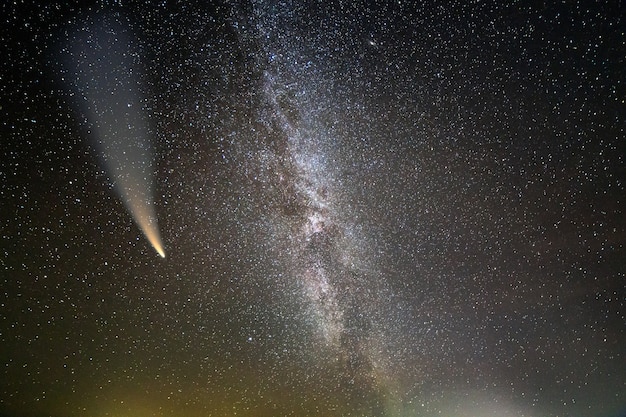 Ночной пейзаж млечного пути со звездами, покрытыми небом, и комета C / 2020 F3 (NEOWISE) со светлым хвостом в темном небе