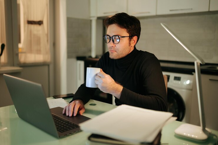 Photo the night owl young adult working late from home a young man is using his laptop and working late in