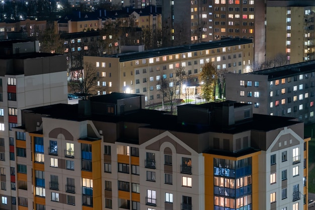 Night panorama of the city Tall apartment buildings illuminated by night illumination Top view of windows and roofs of houses