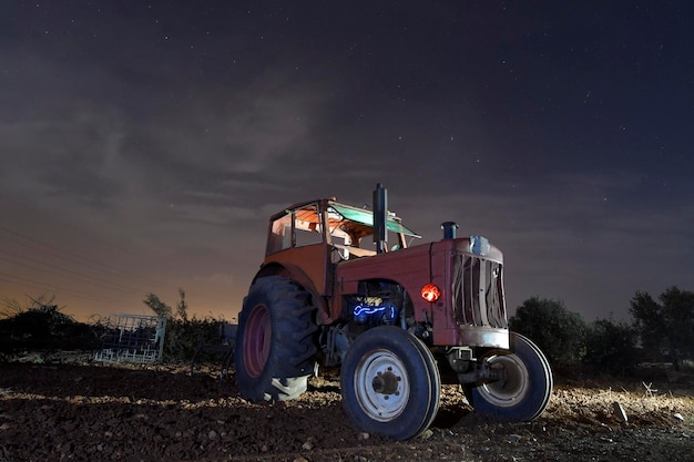 Foto fotografia notturna di un trattore abbandonato