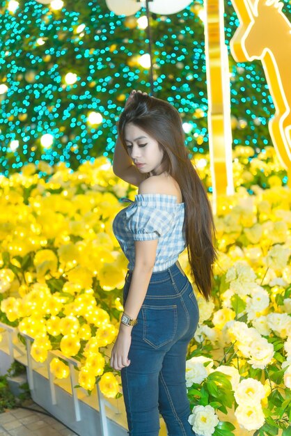 Night portrait of beautiful asian womanthailand girl pose for take a photo on bokeh light at night