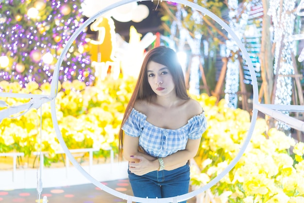 Night portrait of beautiful asian womanThailand girl pose for take a photo on bokeh light at night