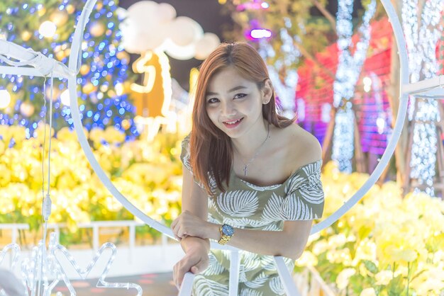 Night portrait of beautiful asian womanThailand girl pose for take a photo on bokeh light at night