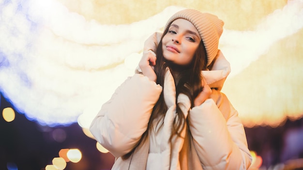 Night portrait of a girl in a winter city on a bokeh background