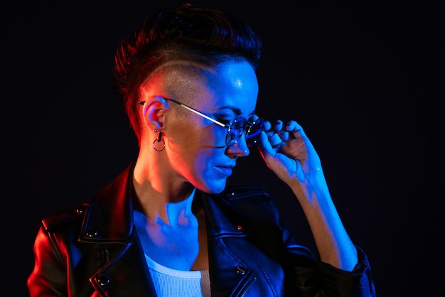 Night portrait of woman neon light positive attitude confident happy woman wearing leather jacket an...