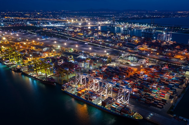 写真 夜景深海港でのコンテナ船の積み下ろし、外洋でのコンテナ船によるビジネスサービスと産業貨物ロジスティックの輸出入貨物輸送の航空写真、
